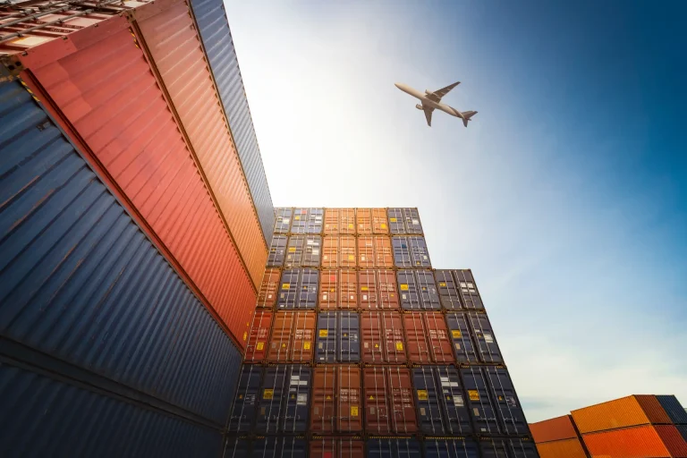 Cargo containers stacked with airplane overhead
