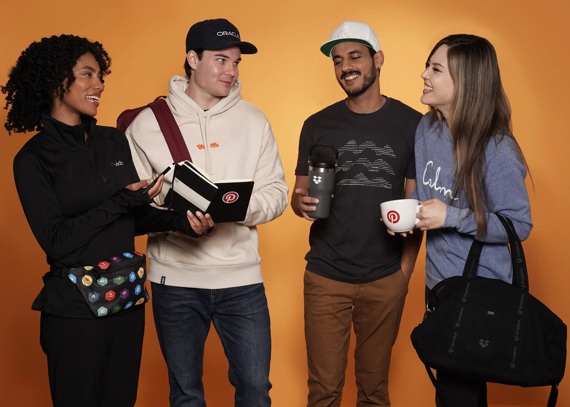 Team displaying branded products and apparel on orange background