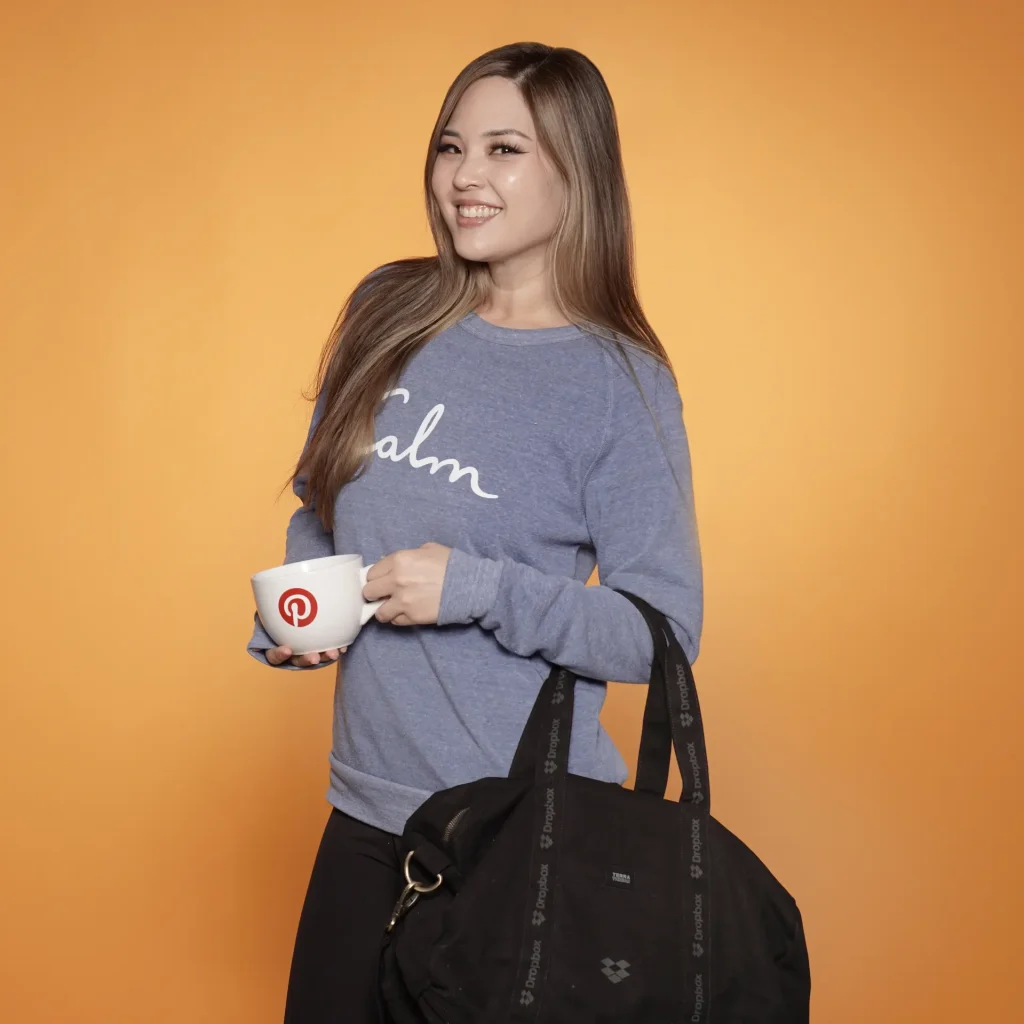 Smiling woman with branded mug and bag