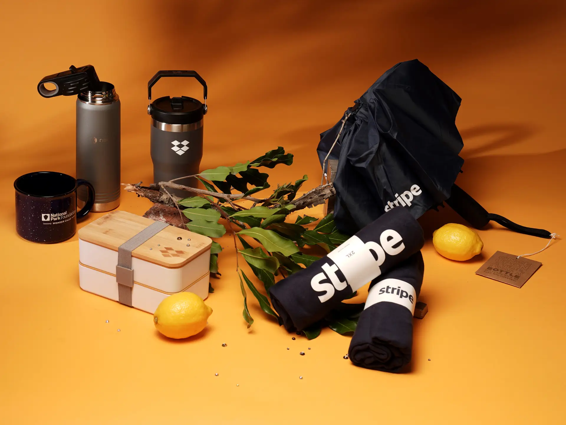 Assorted custom branded merchandise with lemons on orange background