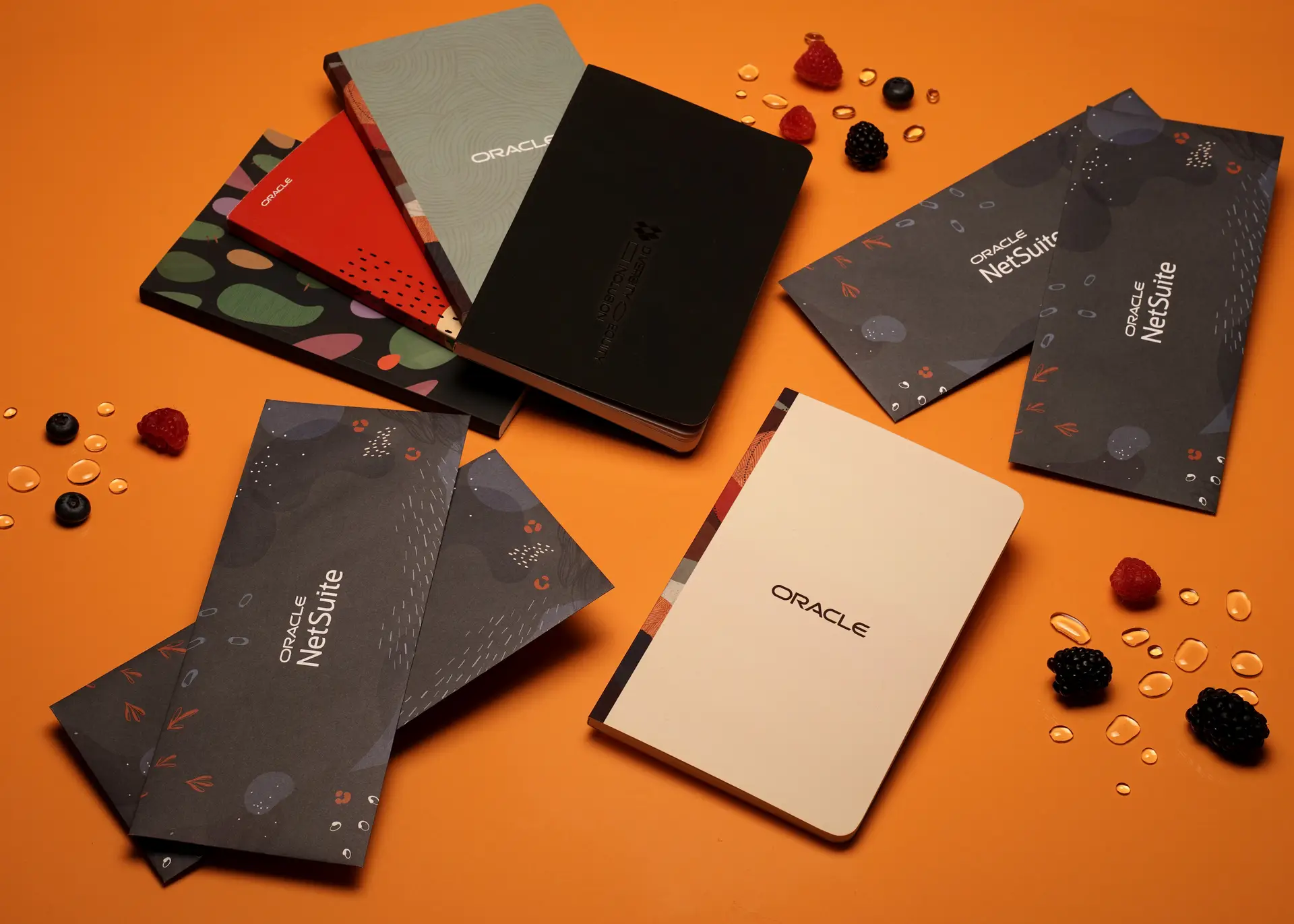 Oracle branded notebooks and envelopes on orange background