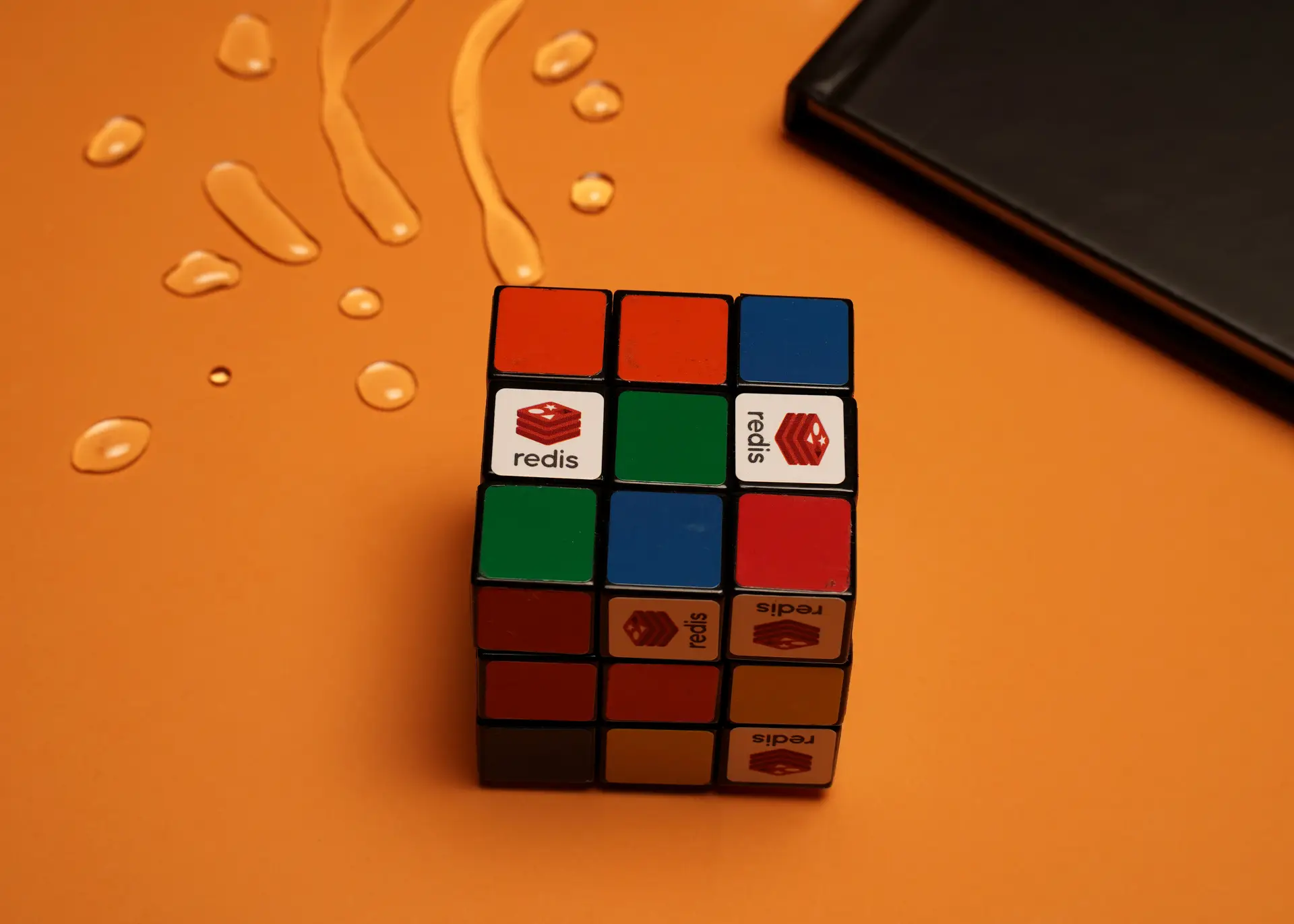 Branded Rubik's Cube with Redis logo on orange background