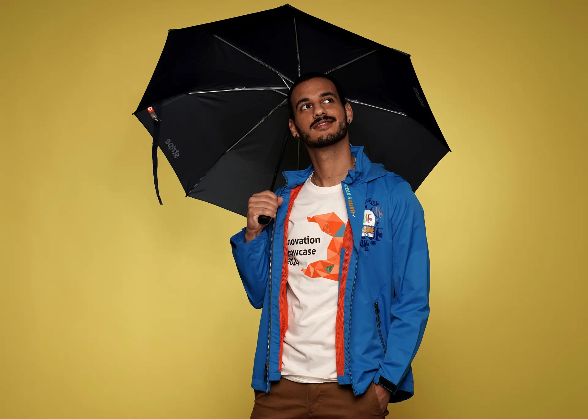 Man posing with branded umbrella and jacket