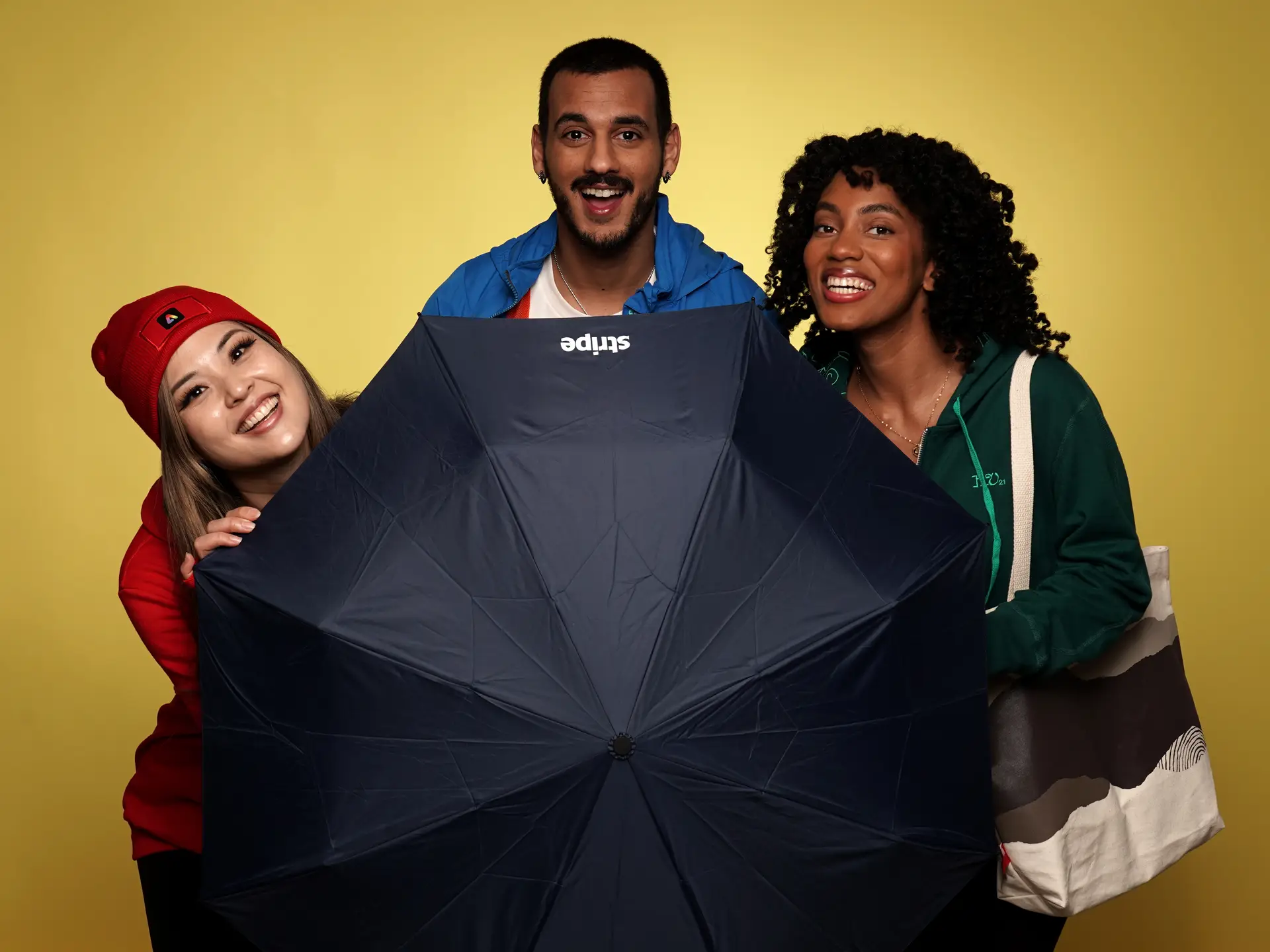 Team enjoying branded umbrella with yellow backdrop