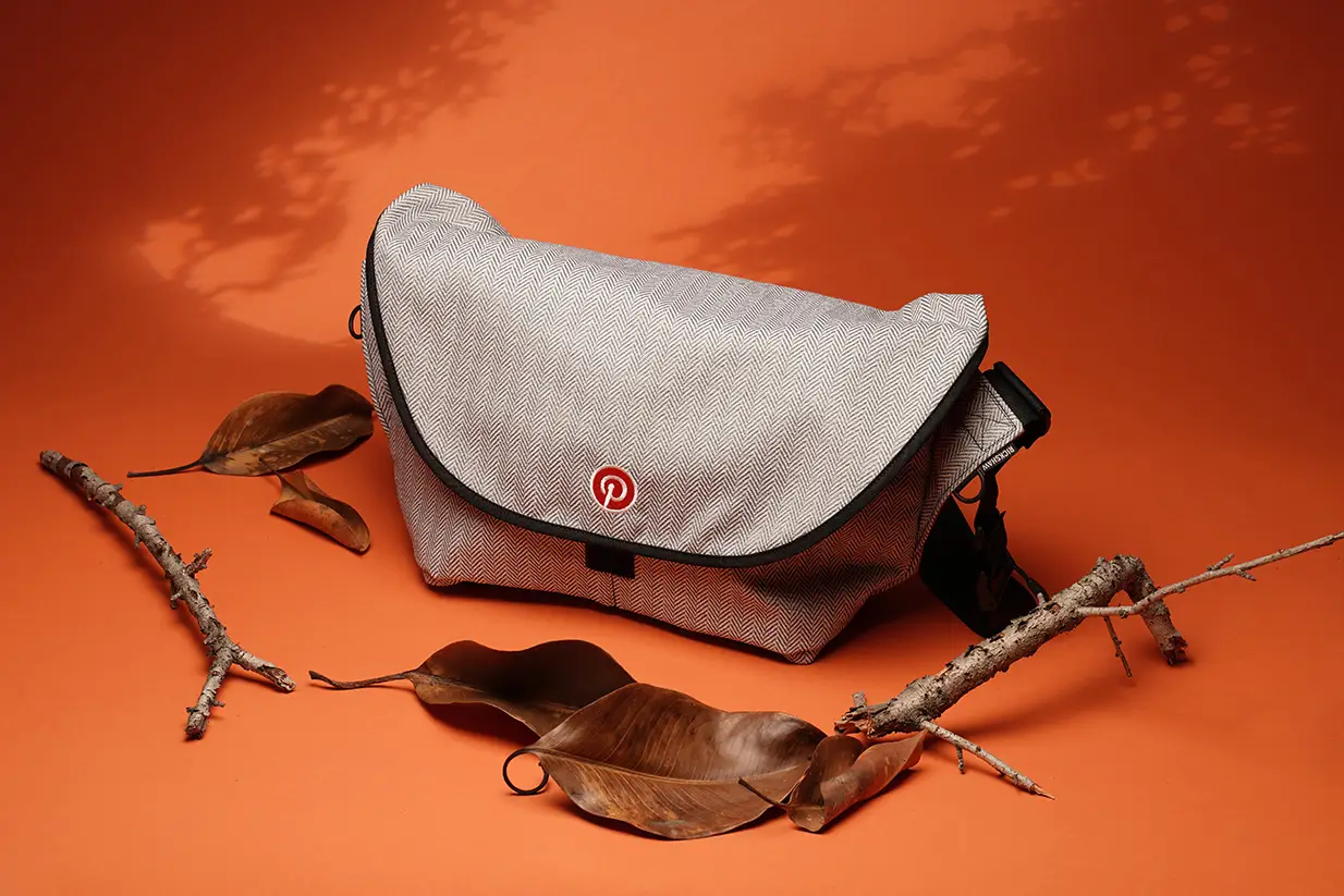 Custom branded messenger bag with logo on orange background