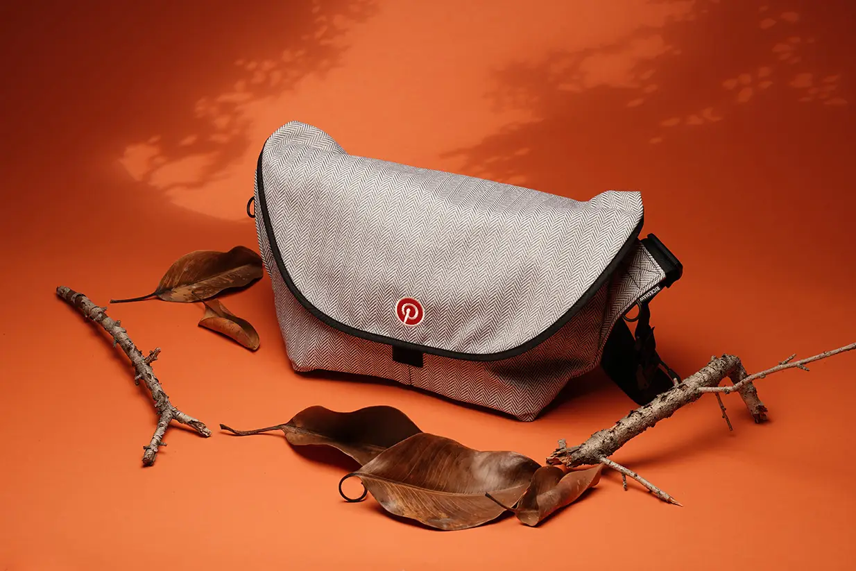 Gray messenger bag with logo on orange background