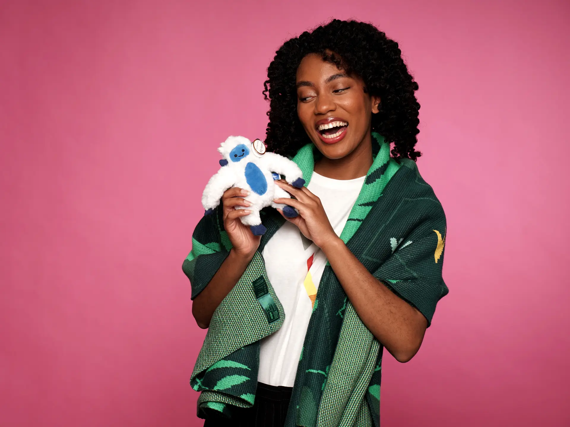 Woman with plush toy and branded scarf, smiling