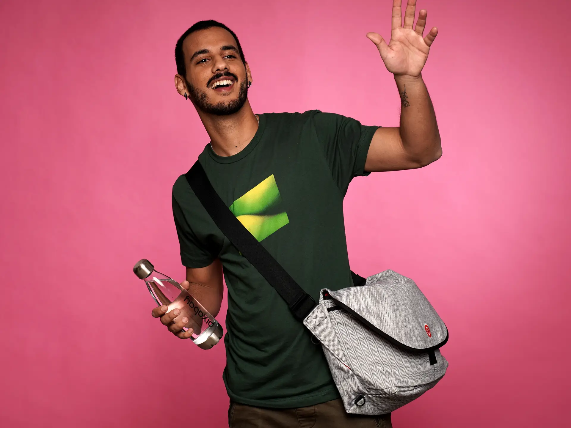 Man waving with branded water bottle and messenger bag