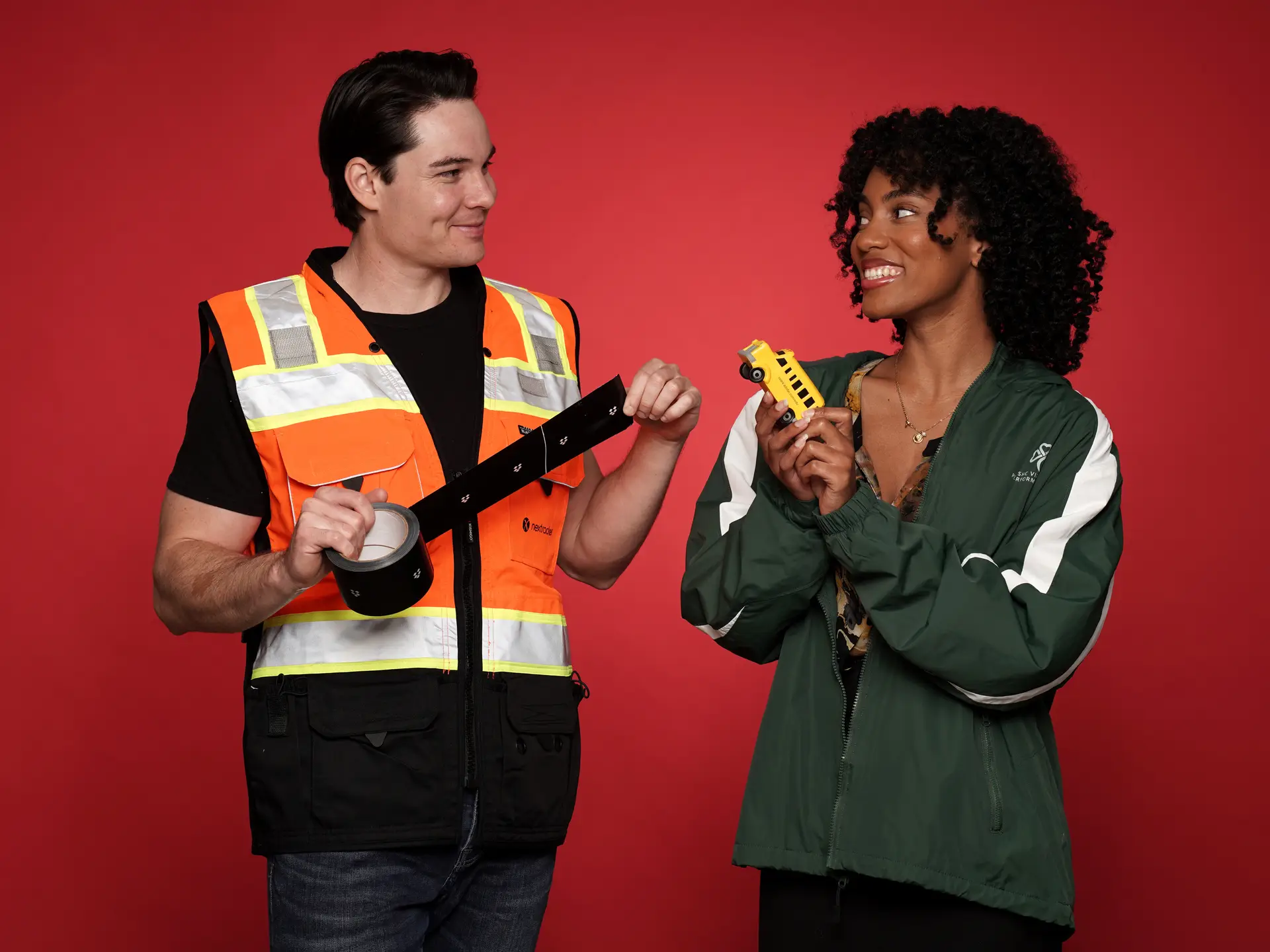 Two people with safety gear and tape measure