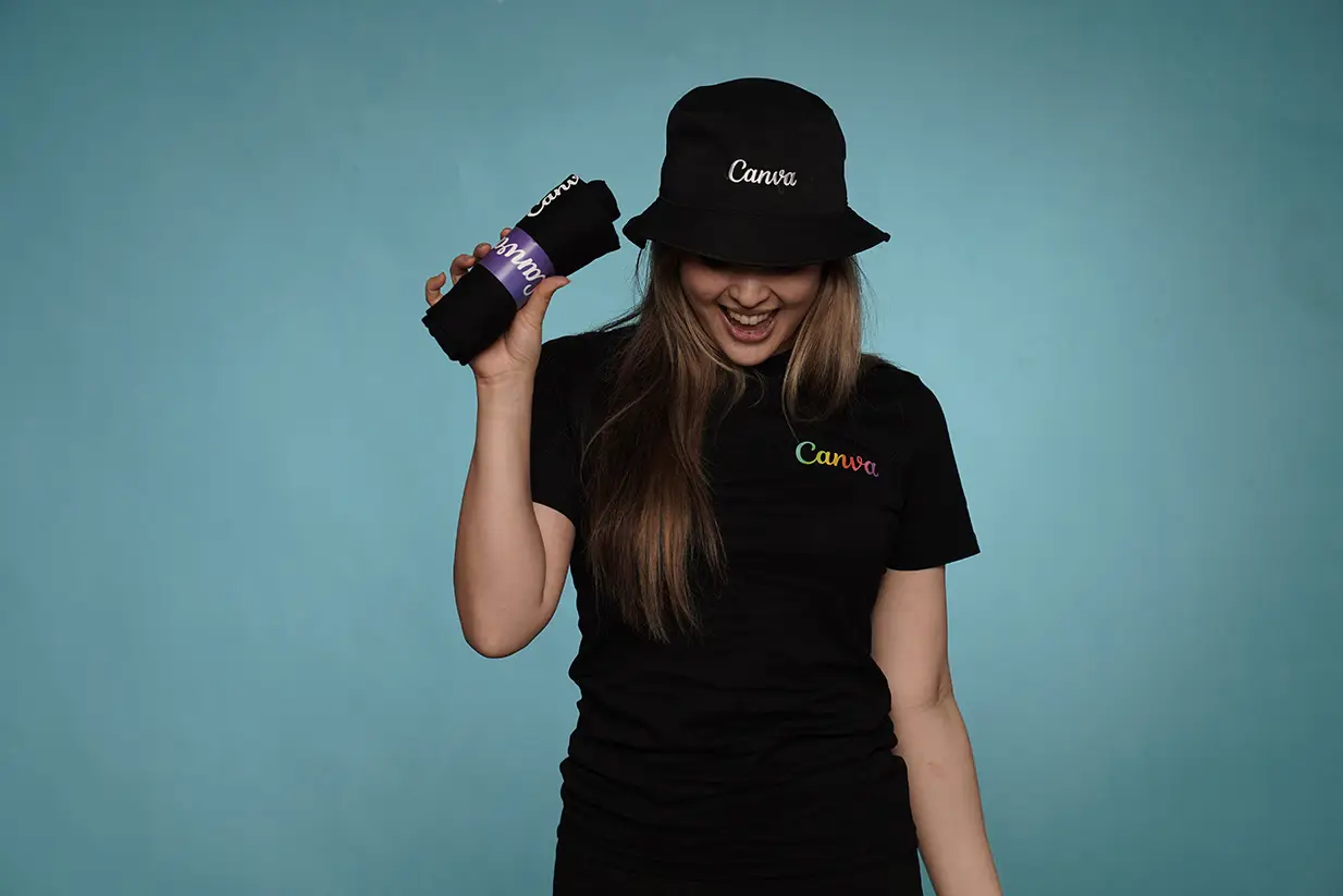 Woman in Canva hat holding branded item