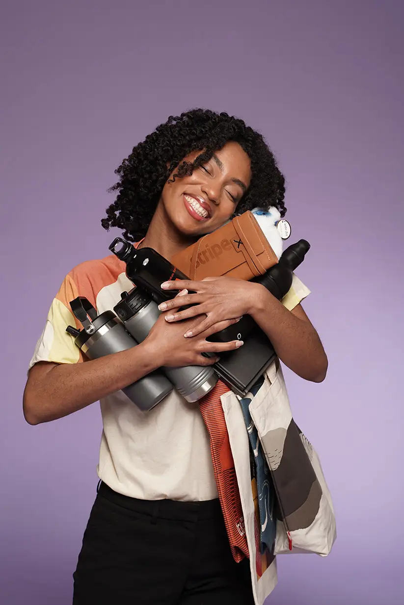 Smiling woman with custom branded merchandise and tote bag