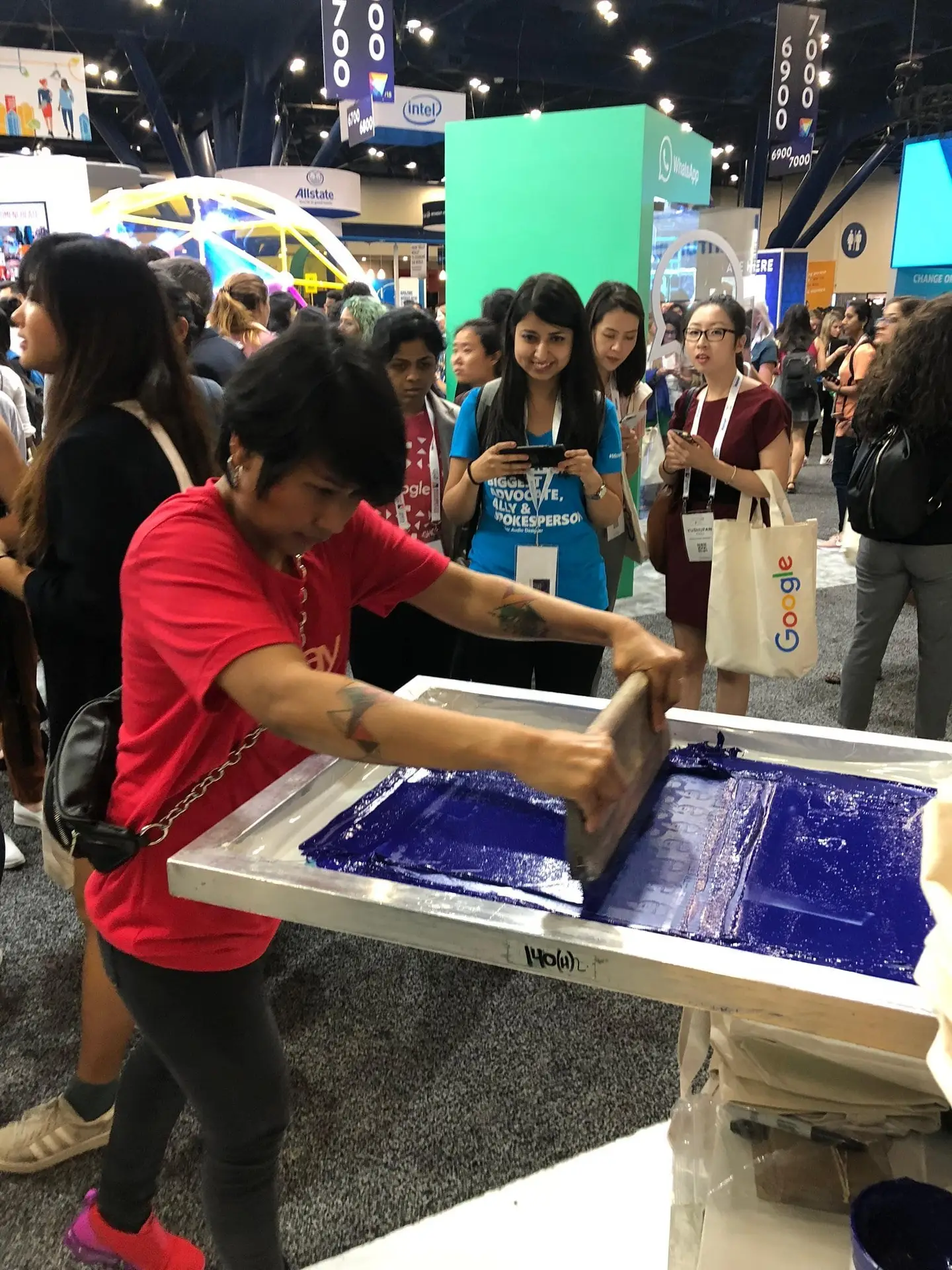 Live screen printing demonstration at a busy corporate event showcasing custom promotional products and branded swag for employee engagement and trade show giveaways.