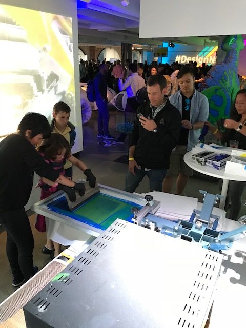 Live screen printing demonstration at corporate event showcasing custom branded merchandise and promotional products for employee swag and giveaways.