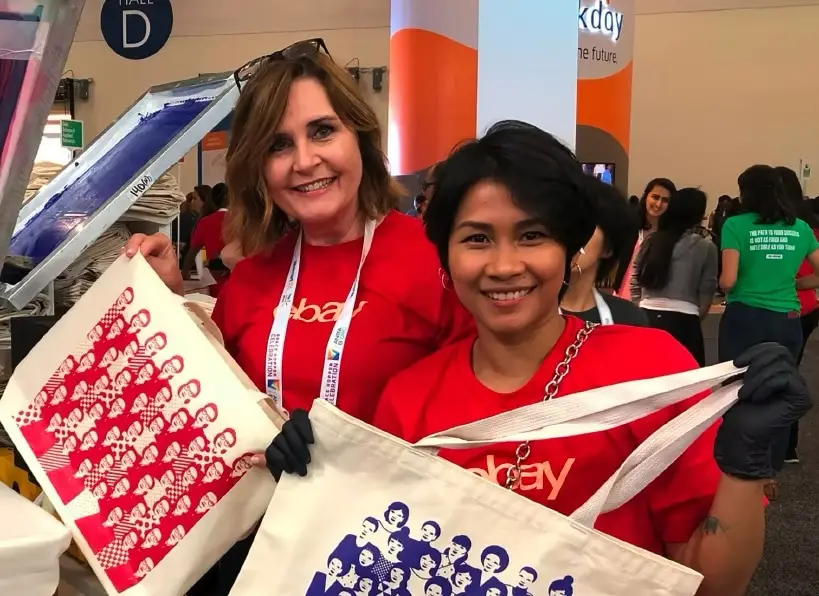 Employees showcasing custom printed tote bags