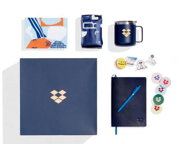Custom branded corporate swag box featuring navy notebook, pen, insulated mug, stickers, and packaging, showcasing premium promotional products for employee gifts and event giveaways.
